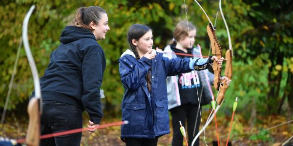 Group of young people doing archery activity