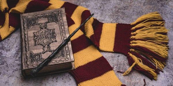 Scarf, magic wand, book of spells on grey stone background