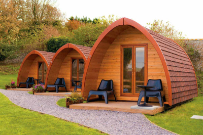 Three wooden camping pods in a row