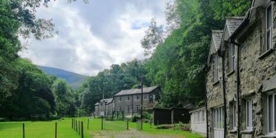 Exterior of both buildings at YHA Kings Two stone hostel buildings surrounded by green lawn and trees