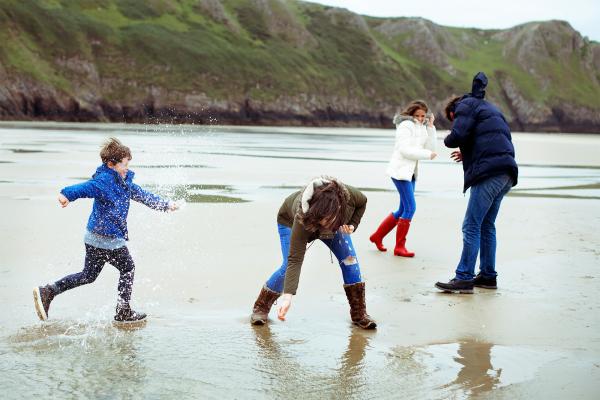 Family playing on a beach in winter