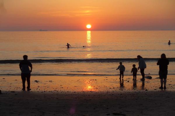 Family on Broad Haven beach at sunset