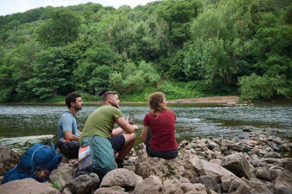 People sat next to a river