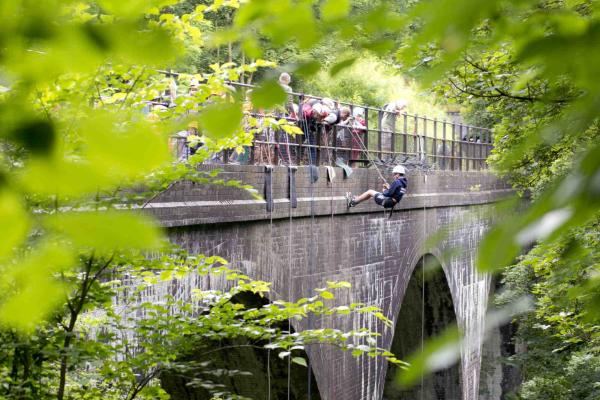 School children abseiling off a bridge in the Peak District