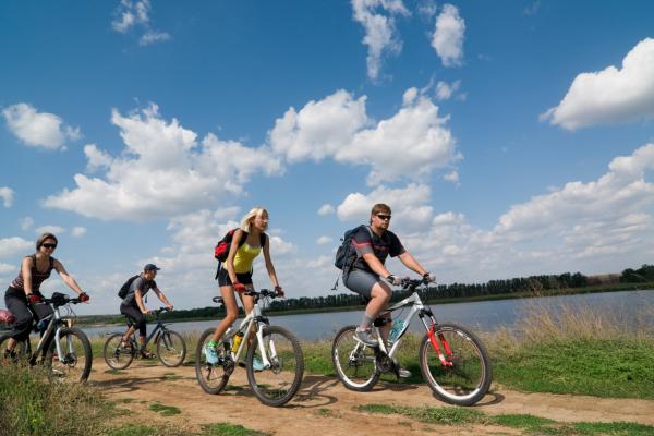 Group of cyclists cycling along the lake