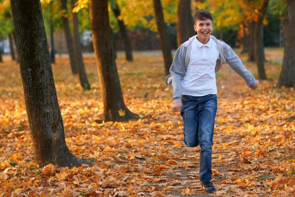 Teenage boy running in forest