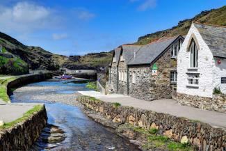 Stone hostel building by a river estuary with a blue sky in the background