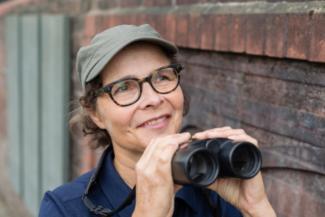Portrait of Amanda Tuke holding binoculars