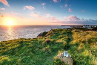 View of sea over cliffs at sunset, Lizard, Cornwall