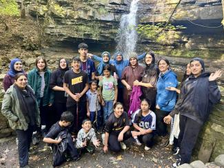 Muslin Youth Alliance attendees smiling in front of a waterfall