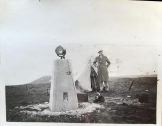 Archived photo of a man camping next to a trig