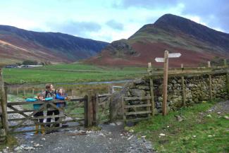 Man and children stood near a gate in the Lake District Man and children stood near a gate in the Lake District