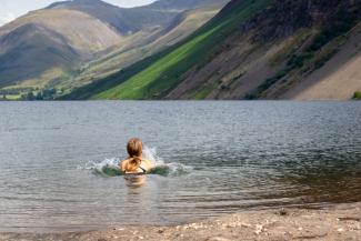 person wild swimming in lake