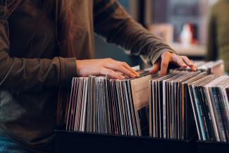 Person browsing vinyl records in a shop