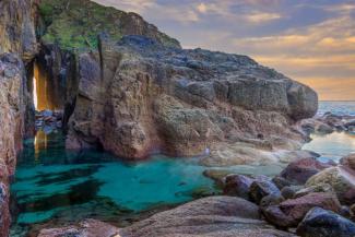 Rugged cove overlooking a pool of bright, blue sea water