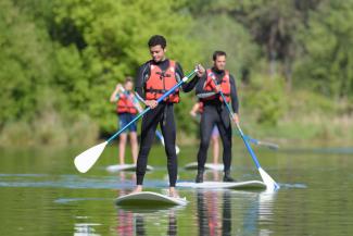 People paddleboarding on river People-paddleboarding-on-river