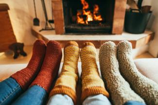 family wearing thick socks in front of fireplace