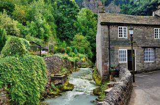 stone cottage with stream running alongside