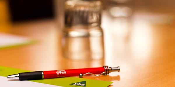 Pen, paper and upturned glass in a YHA meeting room
