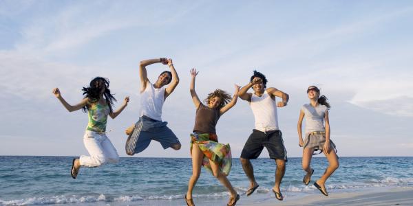 Group of friends jumping on the beach