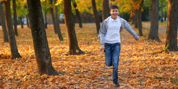 Teenage boy running in forest