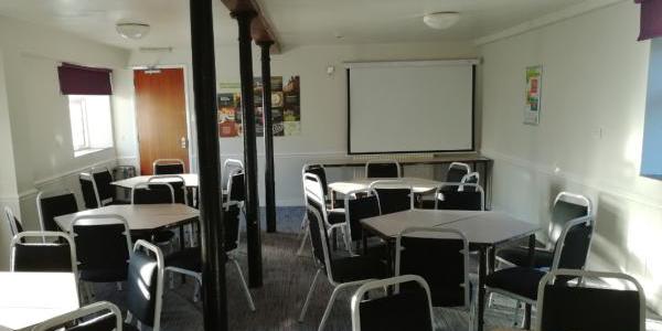 Meeting room at YHA Hartington Hall with six round tables and chairs