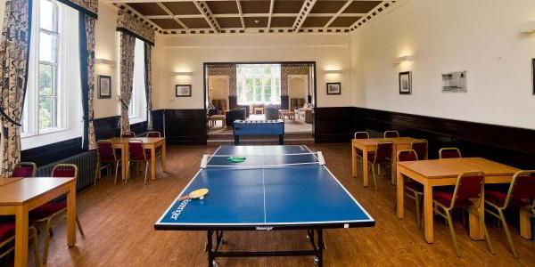 Meeting or games room at YHA Ilam Hall with tables, chairs and table tennis
