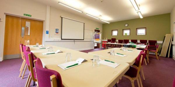 Meeting room at YHA National Forest with u-shaped table configuration and red chairs