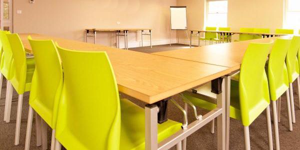 Meeting room at YHA York with u-shaped table configuration and green chairs