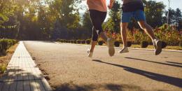 A man and a woman in sportswear are running along the city street in the morning. Runners are running in the city..Jogging. Health. Healthy lifestyle.