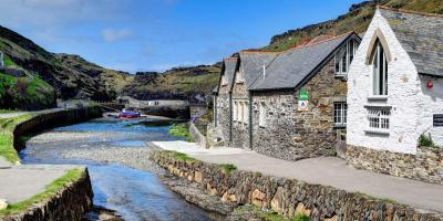 Stone hostel building by a river estuary with a blue sky in the background