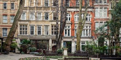 A small area of Postman's park overlooking a row of buildings.
