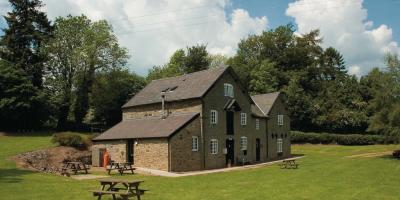 YHA Clun Mill exterior with surrounding garden and outdoor picnic area YHA Clun Mill exterior