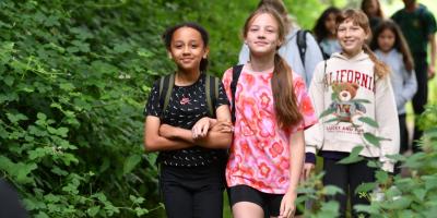 Group of smiling children walking through woodland