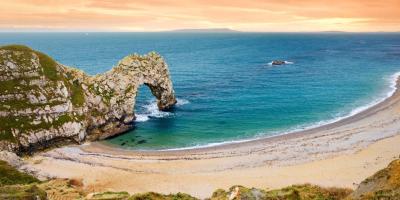 Sandy beach and arch-shaped rock formation overlooking the blue ocean