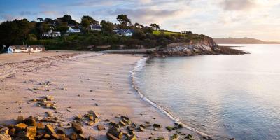 Sandy beach with a sea tide surrounded by small houses