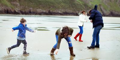 Family playing on a beach in winter