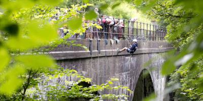 School children abseiling off a bridge in the Peak District