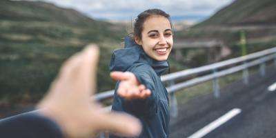 Smiling woman walking with hand held out