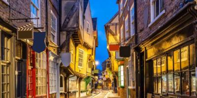 Historic street with different sized shops leaning out into the path