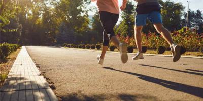 A man and a woman in sportswear are running along the city street in the morning. Runners are running in the city..Jogging. Health. Healthy lifestyle.