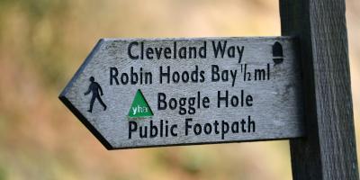 Public footpath sign pointing to YHA Boggle Hole