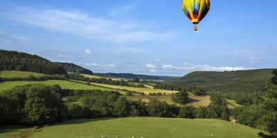 Hot air balloon flying over Yorkshire Dales on a sunny day