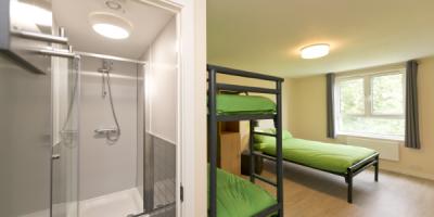 Bedroom with a double bed, set of bunk beds an an open door leading into an en-suite bathroom