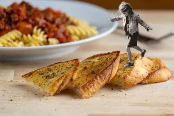 Bowl of pasta with sauce and garlic bread with illustrated child