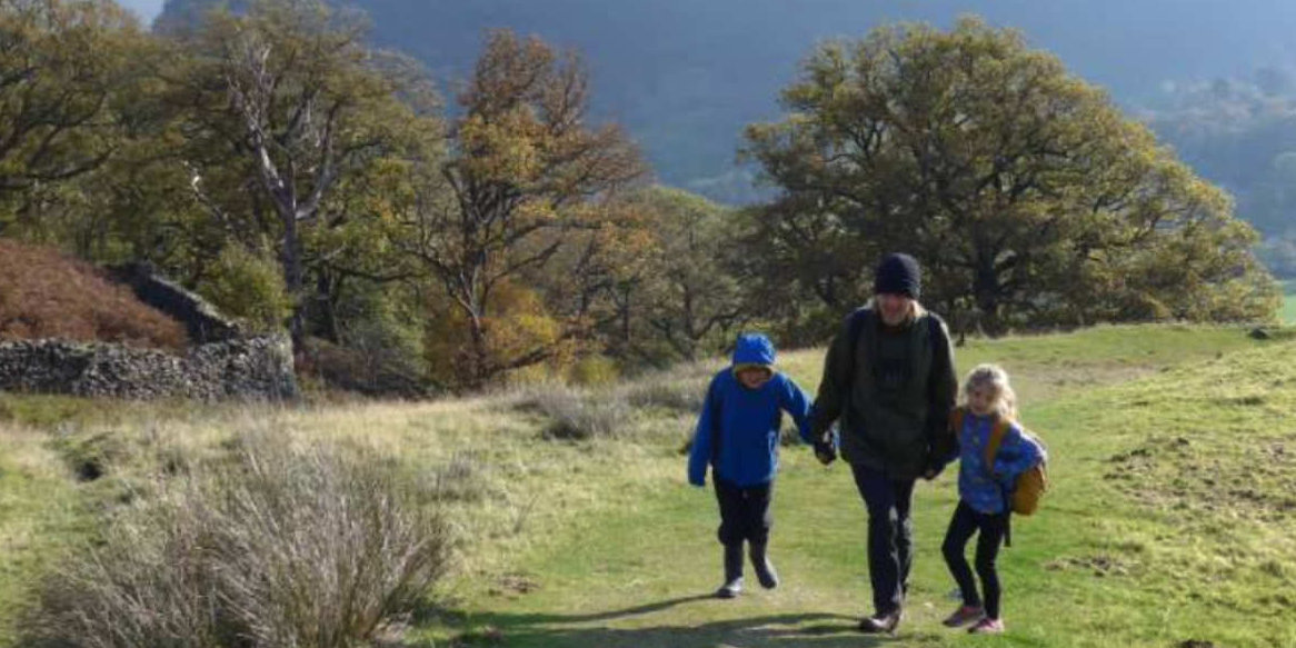 Father and two children walking up a hill