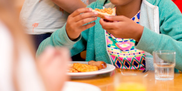 Child eating breakfast with beans on toast