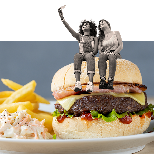 Two women taking a selfie sat on top of a burger