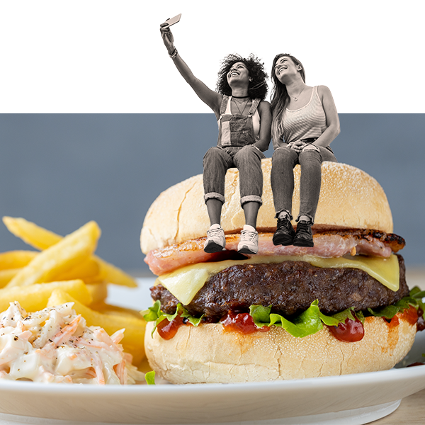 Two women taking a selfie sat on top of a burger