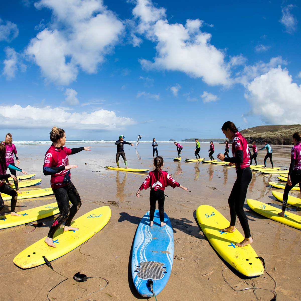 Groups of young people learning to surf on the beach